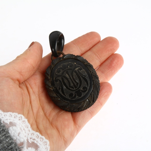 1550 - A 19th century carved jet mourning locket pendant, with monogram front and domed glass backing, 75.1... 