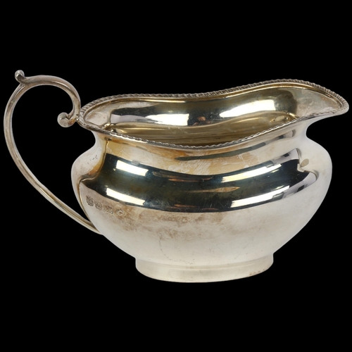 1695 - A George V silver cream jug, Barker Brothers & Sons Ltd, Birmingham 1931, oval bulbous form with gad... 