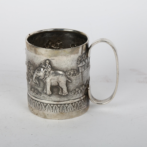 1696 - An Indian silver christening mug, relief embossed decoration depicting figures and elephant in villa... 