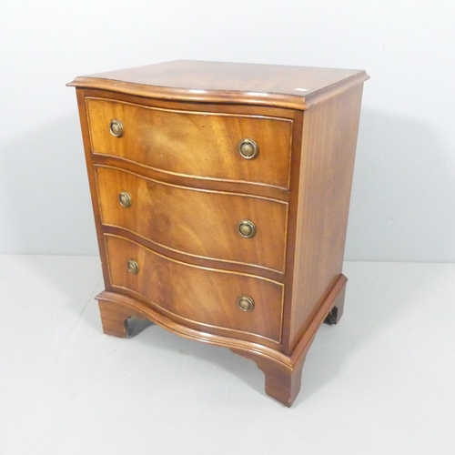 2154 - A reproduction mahogany serpentine chest of three drawers, with label for Reprodux and raised on bra... 