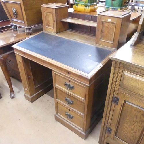 2189 - An early 20th century oak pedestal writing desk, with raised back, lifting lid, three drawers and cu... 