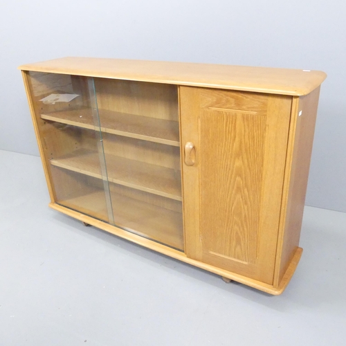 2055 - A mid-century elm bookcase / display cabinet, with one cupboard door and two sliding glass doors wit... 