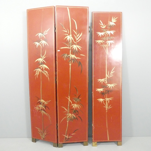 2063 - A Japanese red lacquered three-fold room divider screen, with gilded and painted decoration. Each pa... 