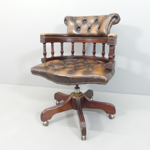 2164 - A Victorian style mahogany and button-back studded-leather upholstered bow arm swivel desk chair.