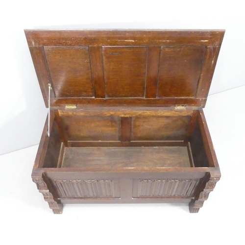 2173 - An early 20th century panelled oak blanked box, with carved linenfold decoration and raised on stile... 