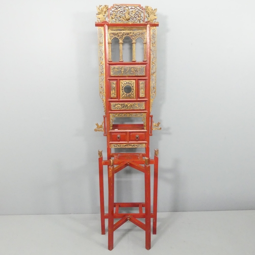 2187 - A Chinese red-lacquered and gilded wash stand, with two drawers, folding front and carved and pierce... 