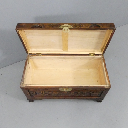 2195 - A small Chinese camphorwood blanket box, with all-over carved decoration. 69x38x33cm.