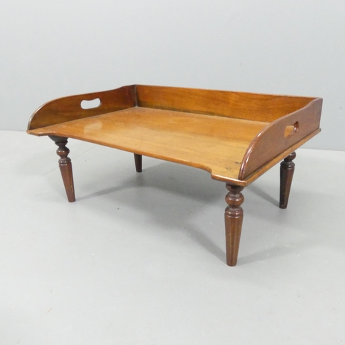 2196 - An antique mahogany bed tray table, raised on turned legs. 61x28x41cm.