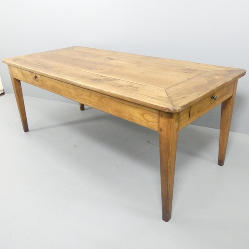 2199 - A French cherry wood and oak plank top dining table, with end frieze drawer and raised on square tap... 