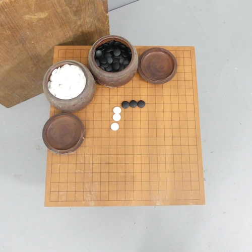 2210 - A vintage Japanese Go-board and stones. Board dimensions 45x27x41cm.