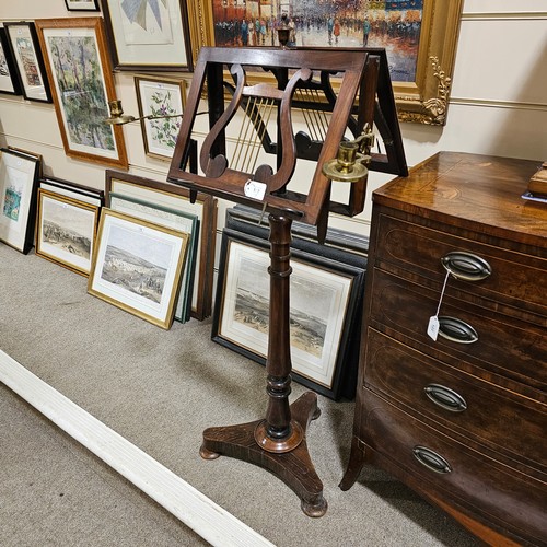 117 - A 19th century rosewood duet music stand, with brass candle brackets, adjustable column and platform... 