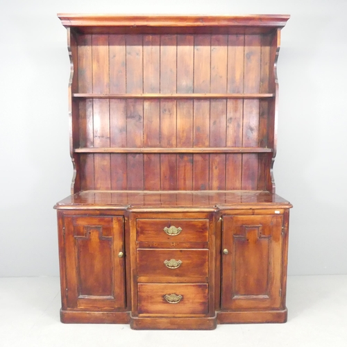 2504 - A stained pine two-section dresser, with inverted break-front base, open plate rack, and three drawe... 