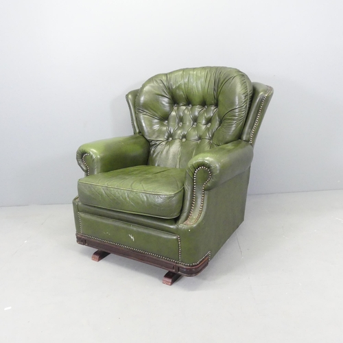 2567 - A green button back leather upholstered Chesterfield style wing back rocking chair.