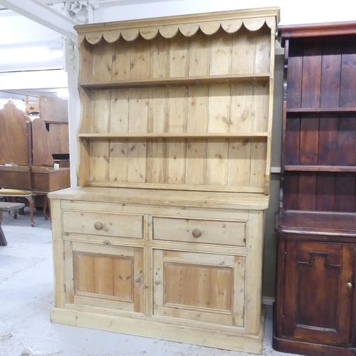 2505 - A vintage pine two-section dresser, with open plate rack and two drawers above two panelled doors. 1... 