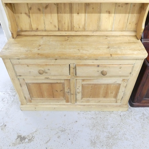 2505 - A vintage pine two-section dresser, with open plate rack and two drawers above two panelled doors. 1... 