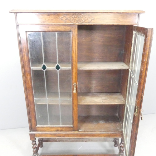 2529 - A 1930s oak bookcase, with two leadlight glazed doors, two adjustable shelves and lattice glazed sup... 