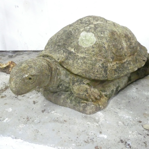 2591 - A weathered concrete garden statue of a tortoise, length45cm, and a scroll shaped pedestal. (2).