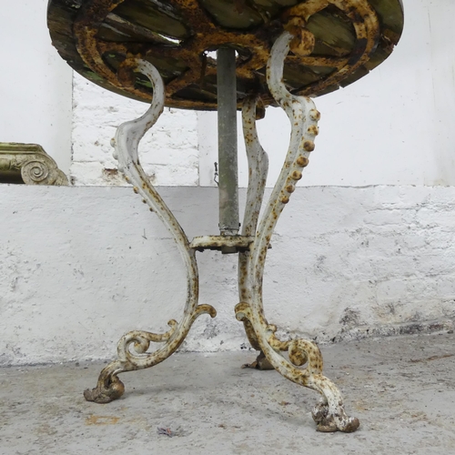 2592 - A weathered teak circular garden table on painted cast iron base. 73x79cm.