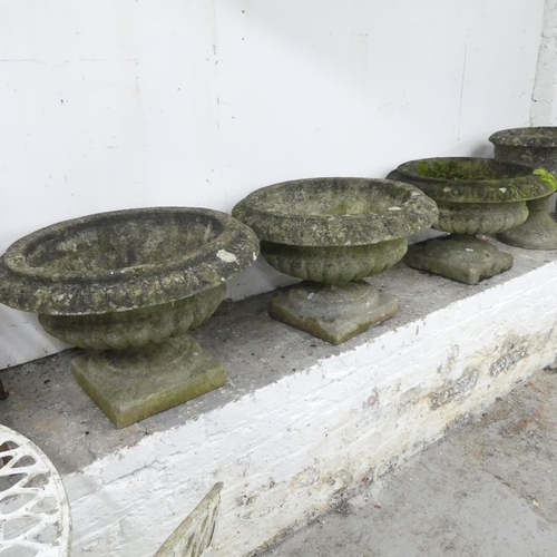 2597 - Three weathered concrete two-section garden urns on stands. 59x40cm.