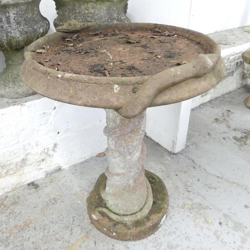 2599 - A two-section weathered concrete bird bath, with serpent decoration. 72x90cm.