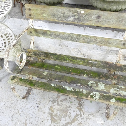 2600 - A teak slatted garden bench with cast iron ends. 180x82x55cm.