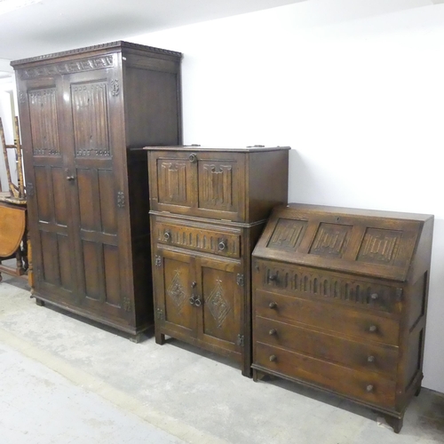 2626 - An early 20th century panelled oak two door wardrobe with linenfold decoration and label for S. Good... 