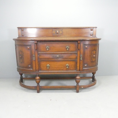 2627 - An Edwardian oak bow-front sideboard, with two drawers between two cupboards and applied carved deco... 