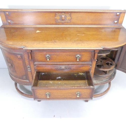 2627 - An Edwardian oak bow-front sideboard, with two drawers between two cupboards and applied carved deco... 