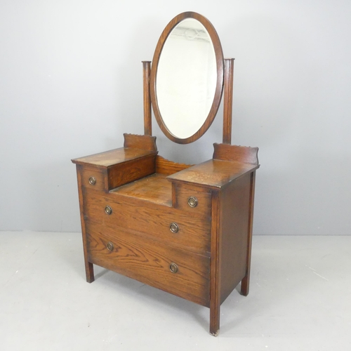 2638 - An oak Arts & Crafts style dressing chest, with raised mirror back and two short and two long drawer... 