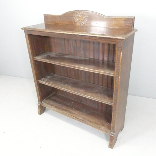 2642 - A 1930s oak open bookcase with two adjustable shelves and applied carved decoration. 91x105x27cm.