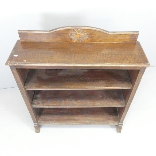 2642 - A 1930s oak open bookcase with two adjustable shelves and applied carved decoration. 91x105x27cm.