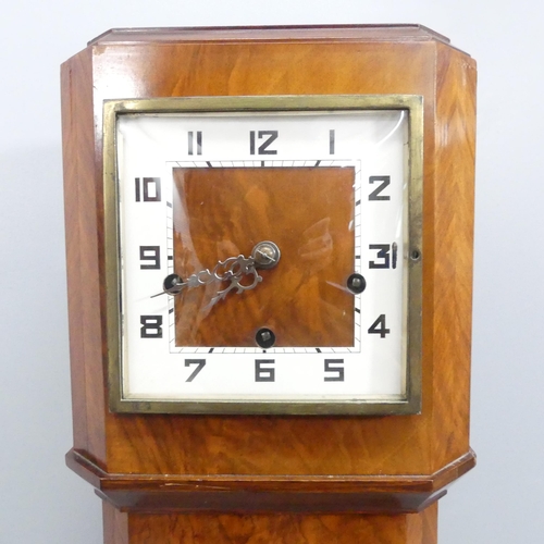 2673 - A walnut cased grandmother clock, with key and pendulum. 24x130x17cm.