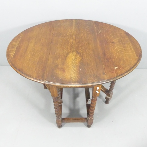 2681 - An antique oak oval gate-leg drop-leaf table on barley twist legs. 86x74x42cm.