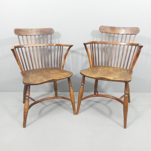 2228 - A near pair of yew-wood and elm-seated comb back Windsor bow arm chairs, with crinoline stretcher.