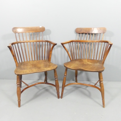 2229 - A near pair of yew-wood and elm-seated comb back Windsor bow arm chairs, with crinoline stretcher.