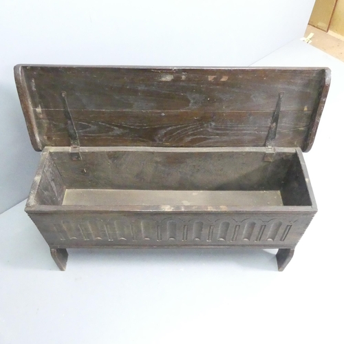 2245 - An antique oak blanket box, with carved decoration and raised on stole legs. 98x48x31cm