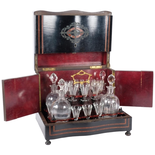 A 19th century Napoleon III French ebonised and rosewood banded table top liqueur cabinet, the rising lid revealing a lift-out fitted glass decanter set. W - 33cm.