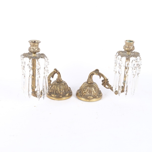 138 - A pair of embossed brass table candelabra with glass lustres. H - 22cm.