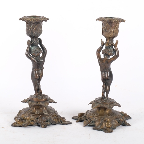 142 - A pair of gilt-bronze candle sticks with cherub design. H - 26cm.