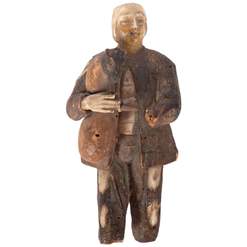 190 - An antique Folk Art carved wood and bone figure of a man playing the bagpipes. H - 15cm.