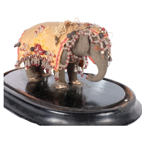 215 - A miniature Indian elephant, with all over jewelled decoration, under a glass dome. H - 16cm.