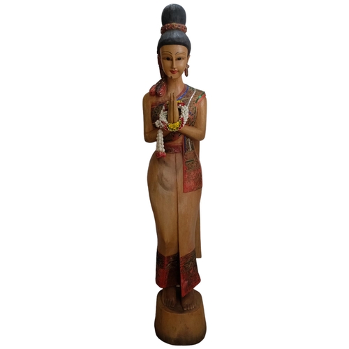 68 - A Thai carved and painted wood figure of a Sawasdee female. H - 152cm.