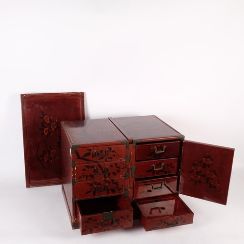 397 - A Japanese red lacquered table top jewellery/travelling chest, converting to miniature desk, with fi... 