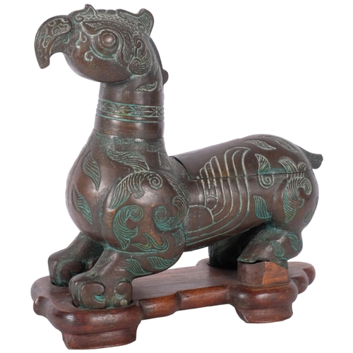 413 - An Oriental verdigris bronze mythical beast, on fitted wooden stand, H23cm