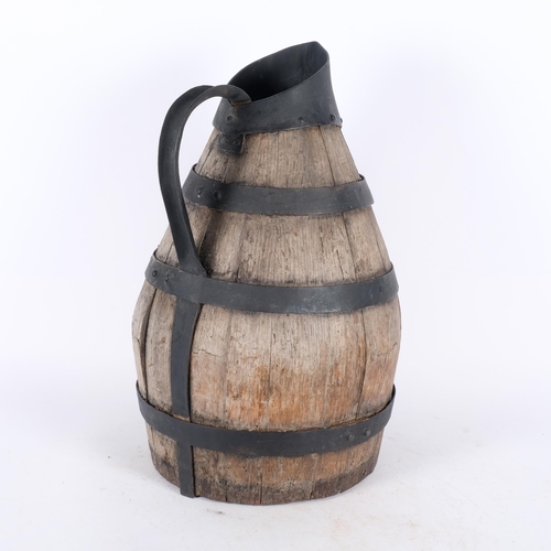 273 - An Antique Continental coopered oak jug with metal bands and handle, H46cm