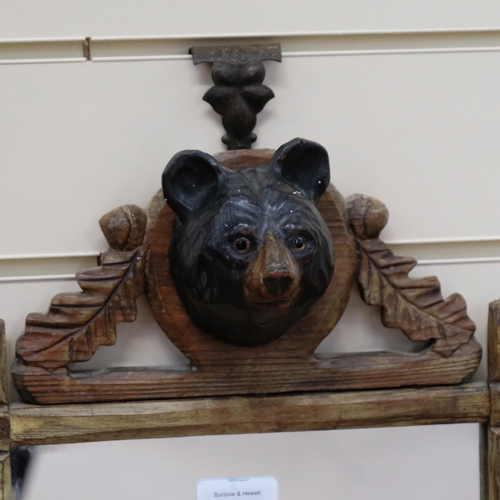 361 - Black Forest carved oak framed wall mirror, with bear's head pediment, H53cm