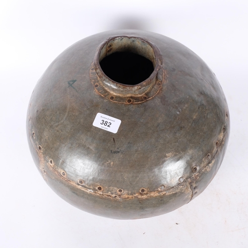 382 - A studded metal industrial vase. 35cm diameter