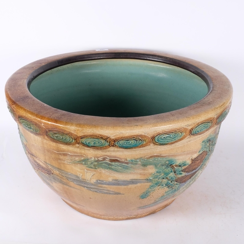 388 - A large Japanese stoneware bowl with plug, moriage with incised and tube-lined landscape decoration ... 