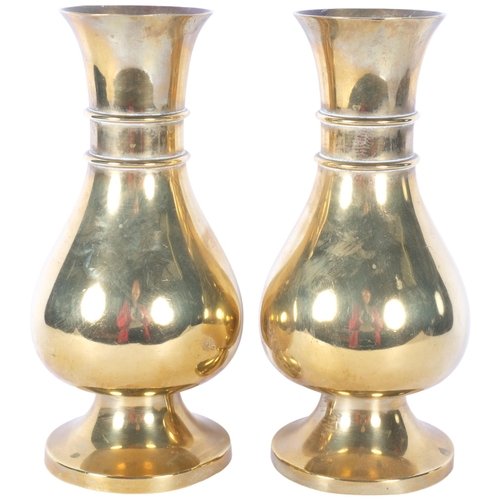 407 - A pair of heavy brass vases on feet, 25.5cm