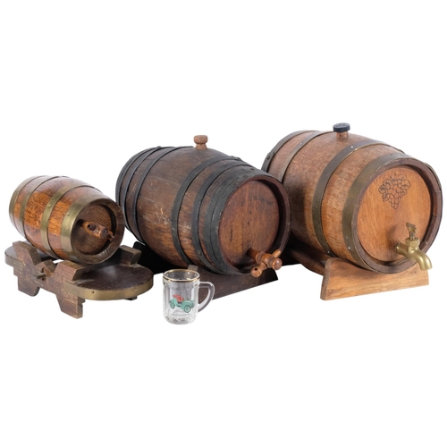 544 - A group of 3 Whisky or wine barrels, brass and iron-bound, on associated display stands, all with ta... 